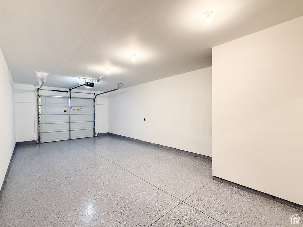 Garage with baseboards and a garage door opener