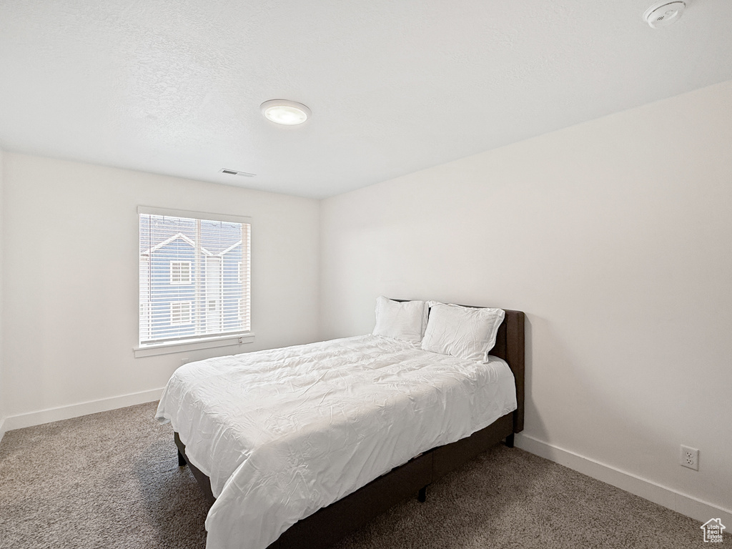 Bedroom with baseboards, visible vents, and carpet