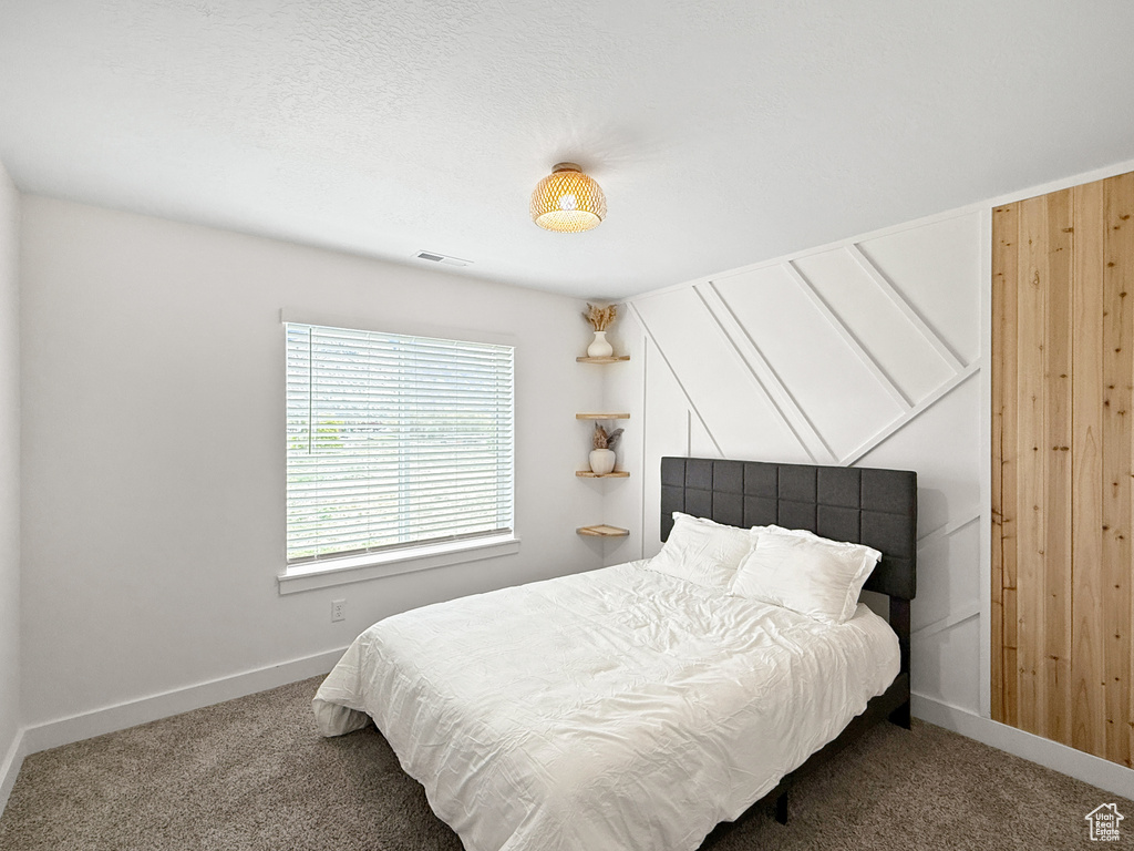 Carpeted bedroom featuring visible vents and baseboards