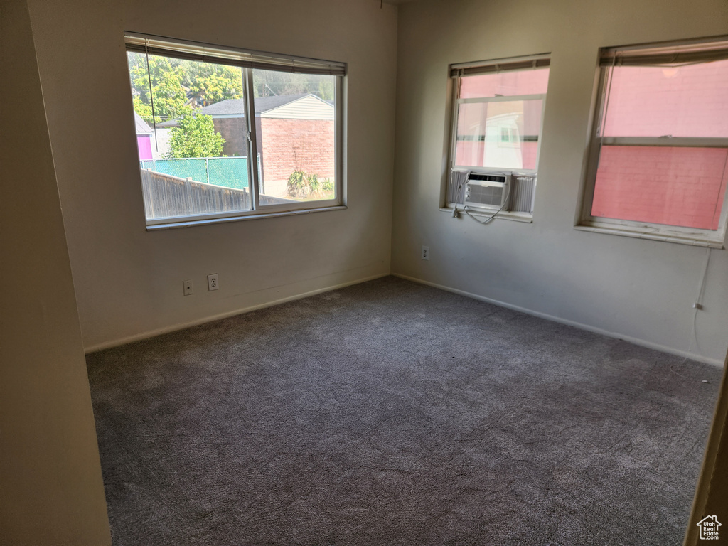 Carpeted empty room with baseboards and cooling unit