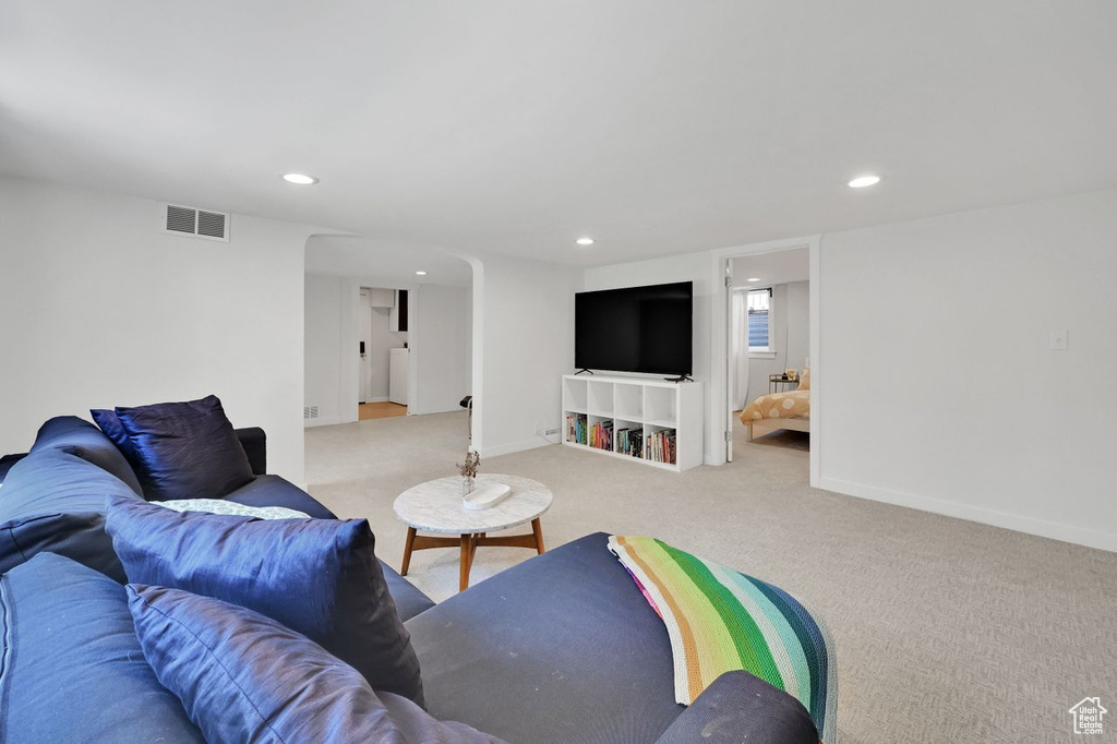 Carpeted living room with visible vents, recessed lighting, and baseboards