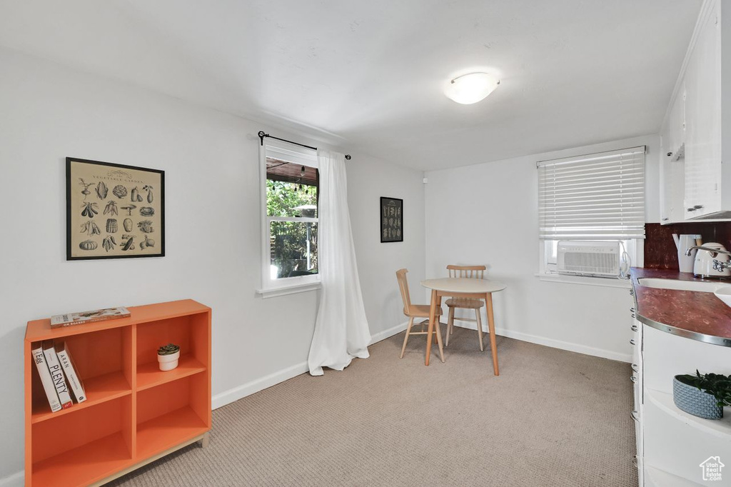 Dining area featuring baseboards, cooling unit, and light colored carpet