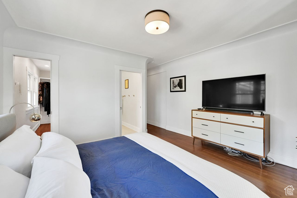 Bedroom with baseboards and dark wood-type flooring