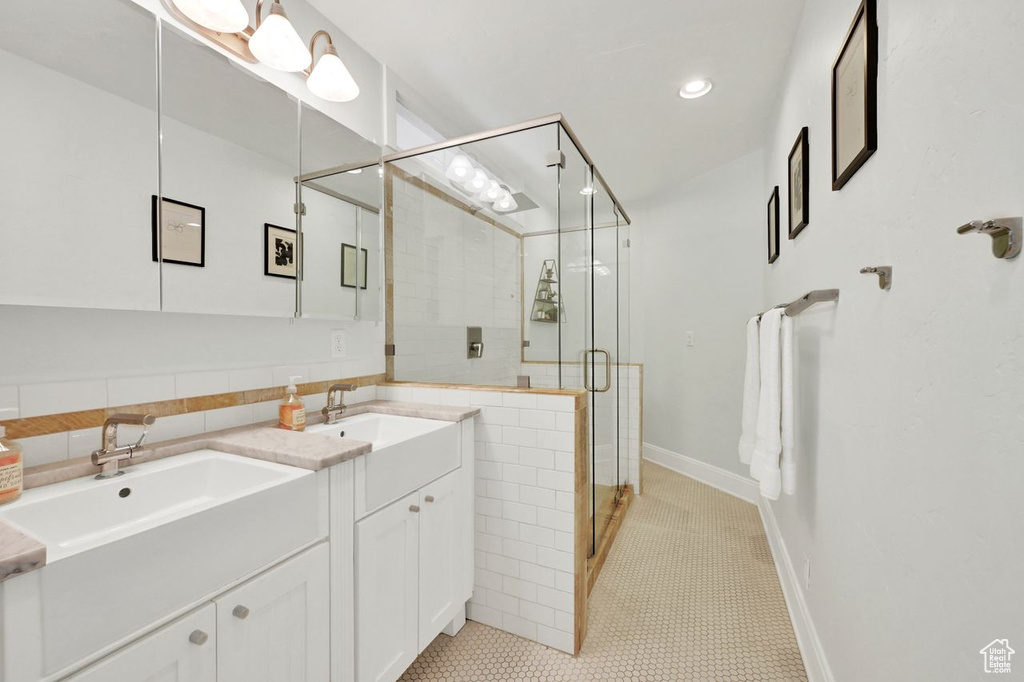 Bathroom featuring a sink, a stall shower, recessed lighting, and double vanity