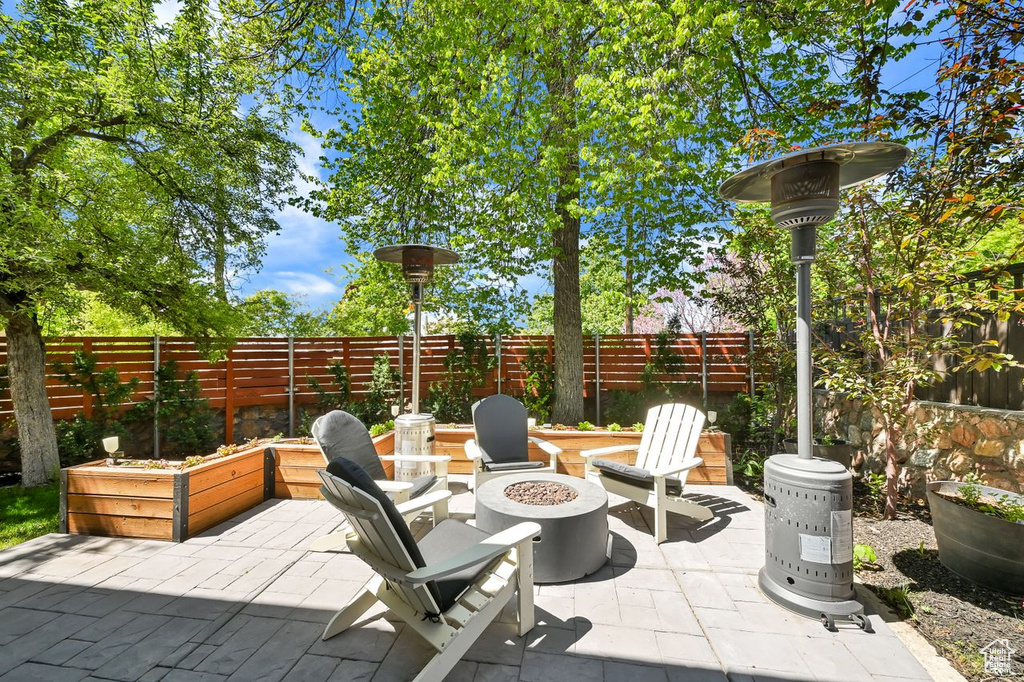View of patio with a fenced backyard and an outdoor fire pit