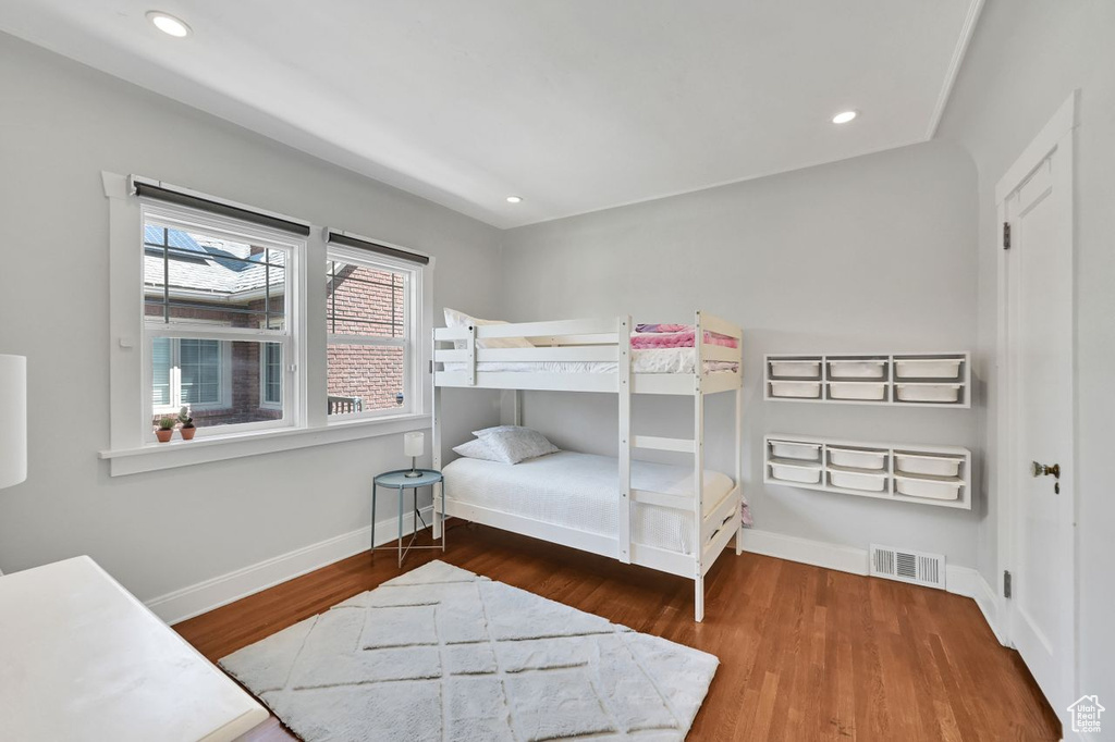 Bedroom with baseboards, recessed lighting, wood finished floors, and visible vents