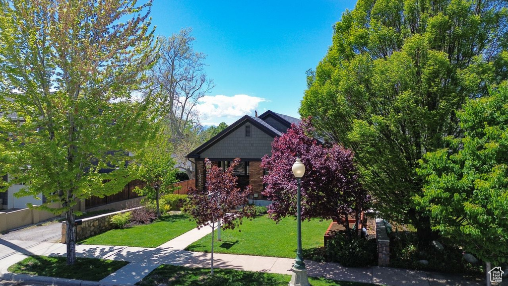 Traditional home featuring brick siding, fence, and a front yard