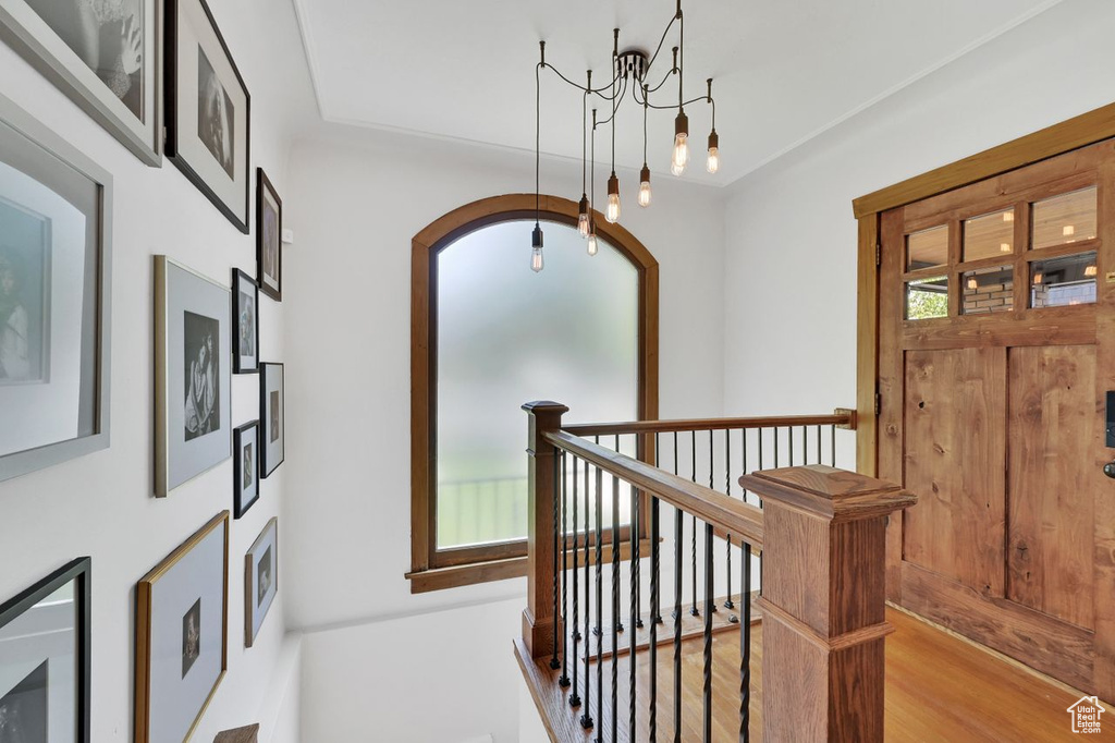 Entryway with arched walkways, a chandelier, and wood finished floors