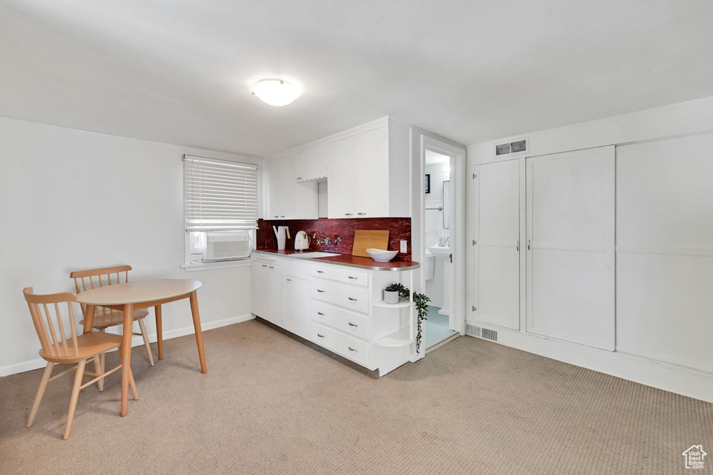 Interior space featuring light colored carpet, visible vents, and a sink