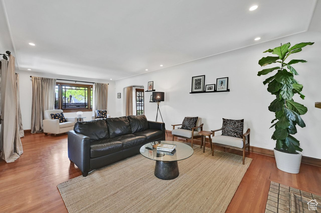 Living area featuring recessed lighting, arched walkways, and wood finished floors