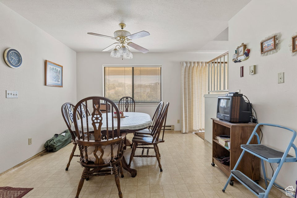 Dining area featuring a ceiling fan and light floors