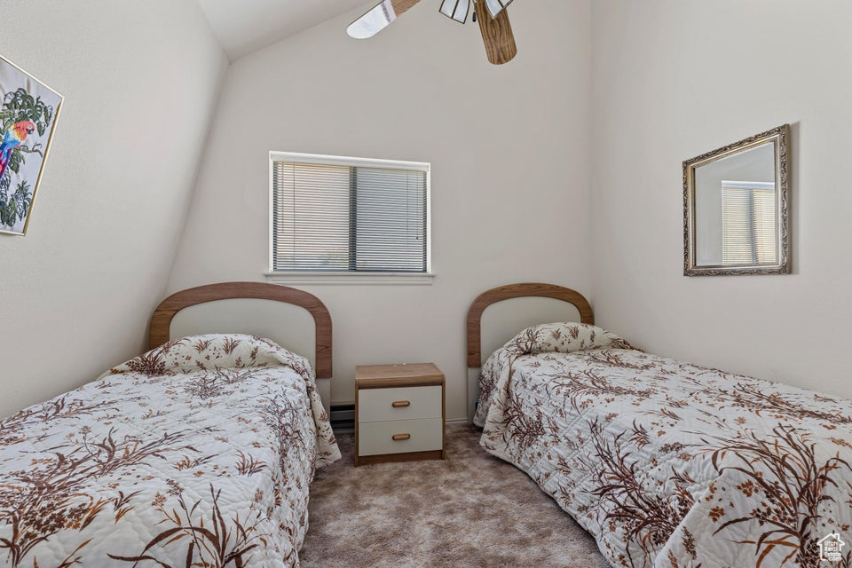 Bedroom with a ceiling fan, high vaulted ceiling, carpet, and a baseboard radiator