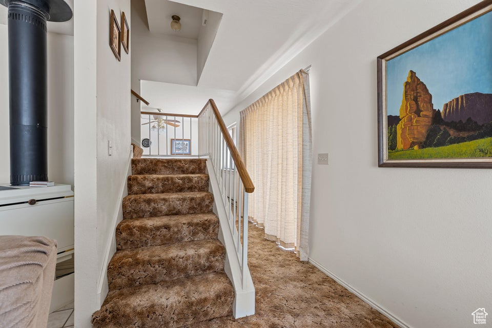 Staircase featuring baseboards and carpet