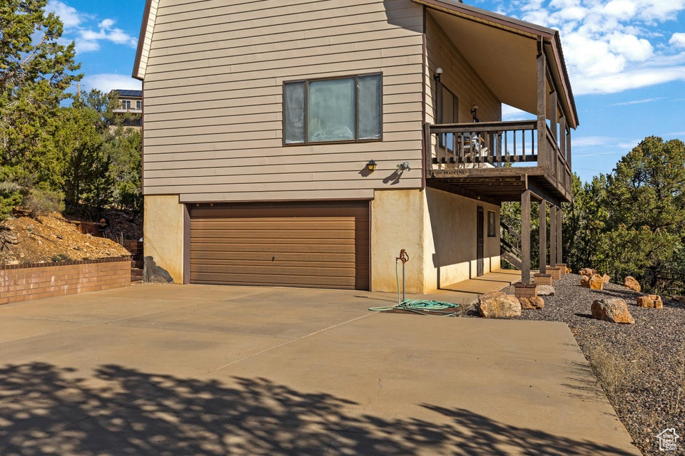 View of front of home featuring a garage, driveway, and a deck