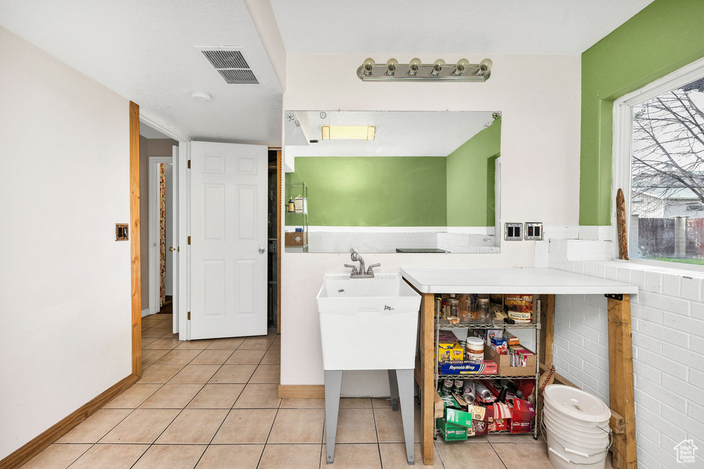 Laundry area featuring light tile patterned flooring and visible vents