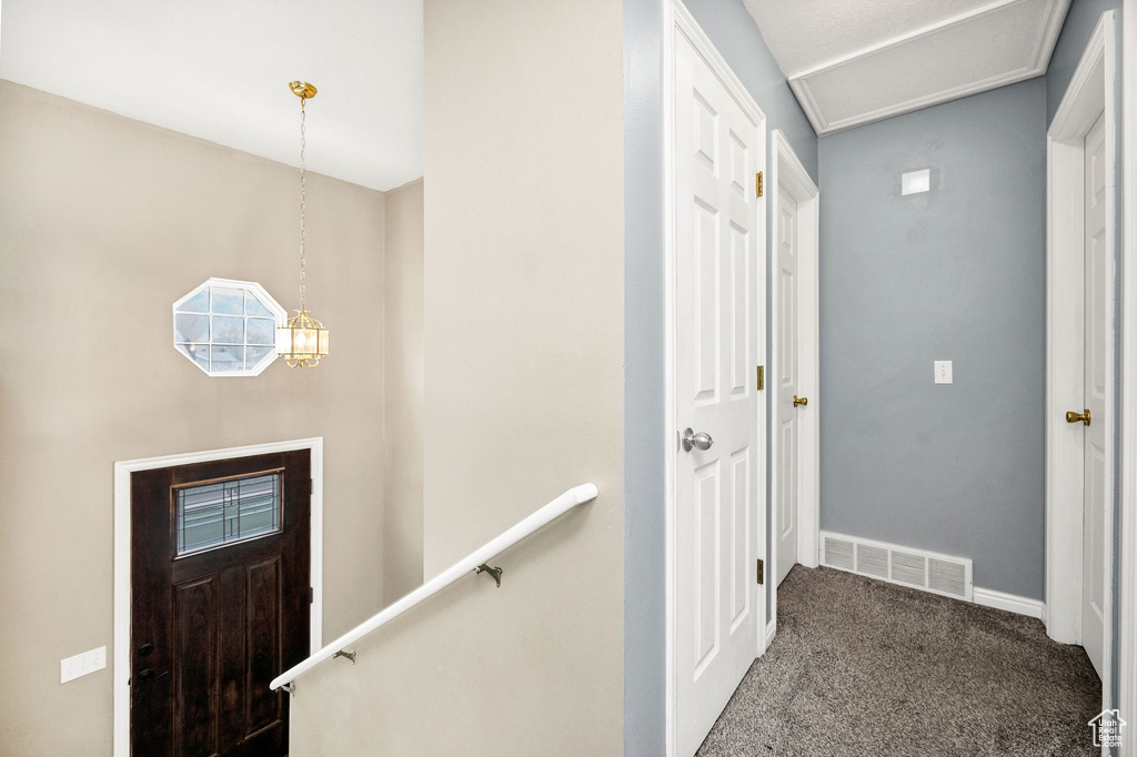 Carpeted foyer with visible vents and baseboards