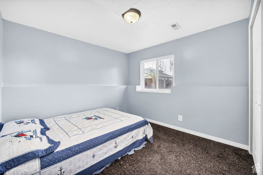 Carpeted bedroom with baseboards and visible vents