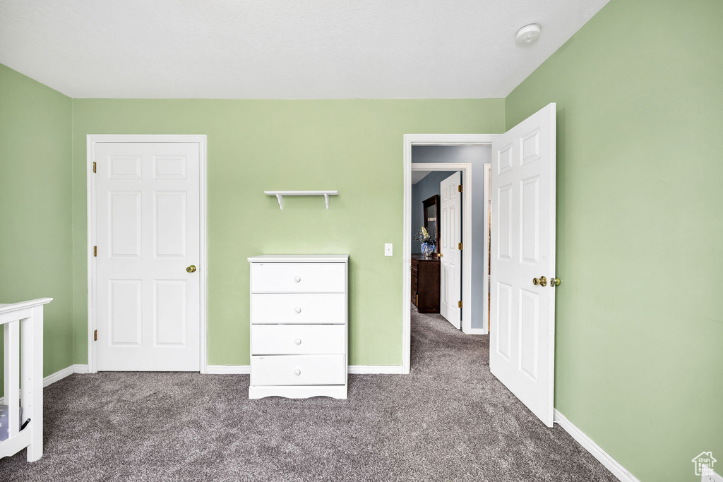 Unfurnished bedroom with carpet floors and baseboards