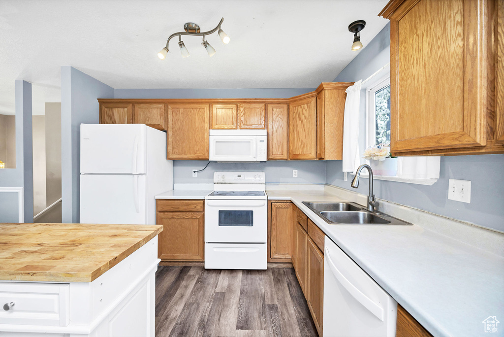 Kitchen with a sink, wood counters, white appliances, and dark wood-style floors