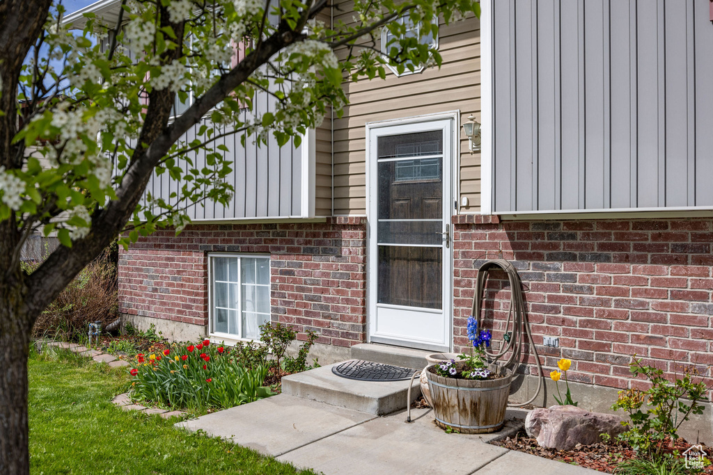 Entrance to property with board and batten siding and brick siding