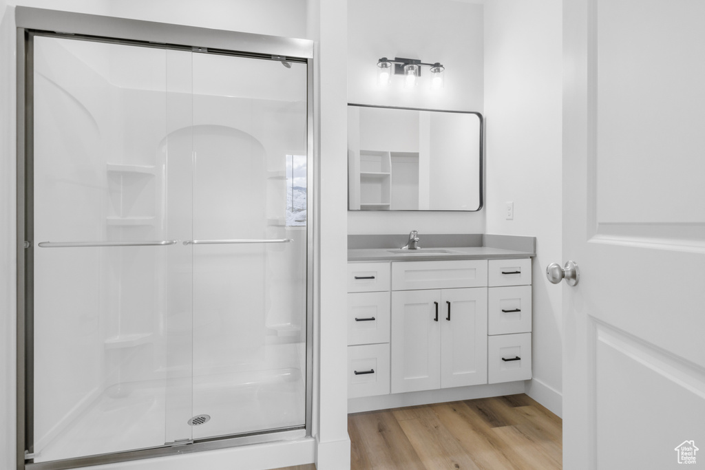 Bathroom with vanity, a shower stall, and wood finished floors
