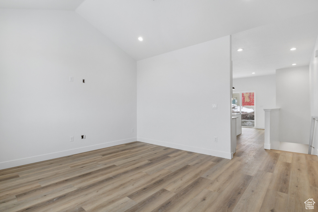 Unfurnished room with recessed lighting, light wood-style flooring, vaulted ceiling, and baseboards