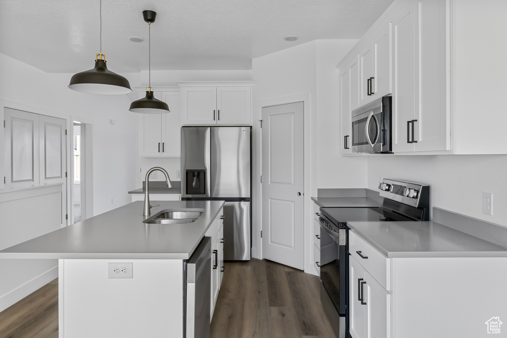 Kitchen featuring a sink, white cabinets, appliances with stainless steel finishes, and dark wood finished floors