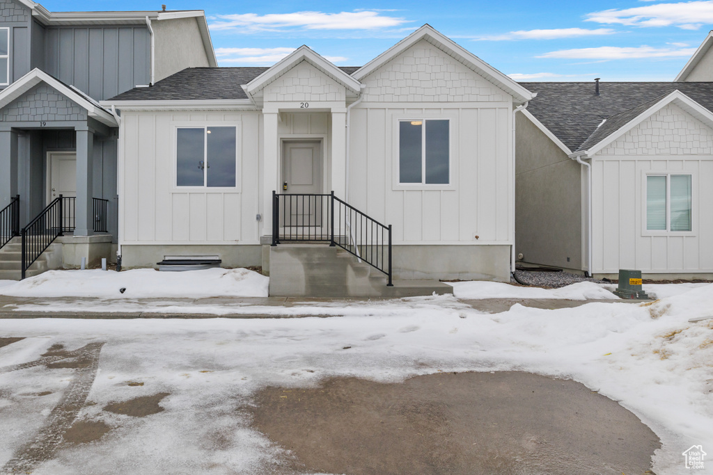 View of front of home with board and batten siding and roof with shingles