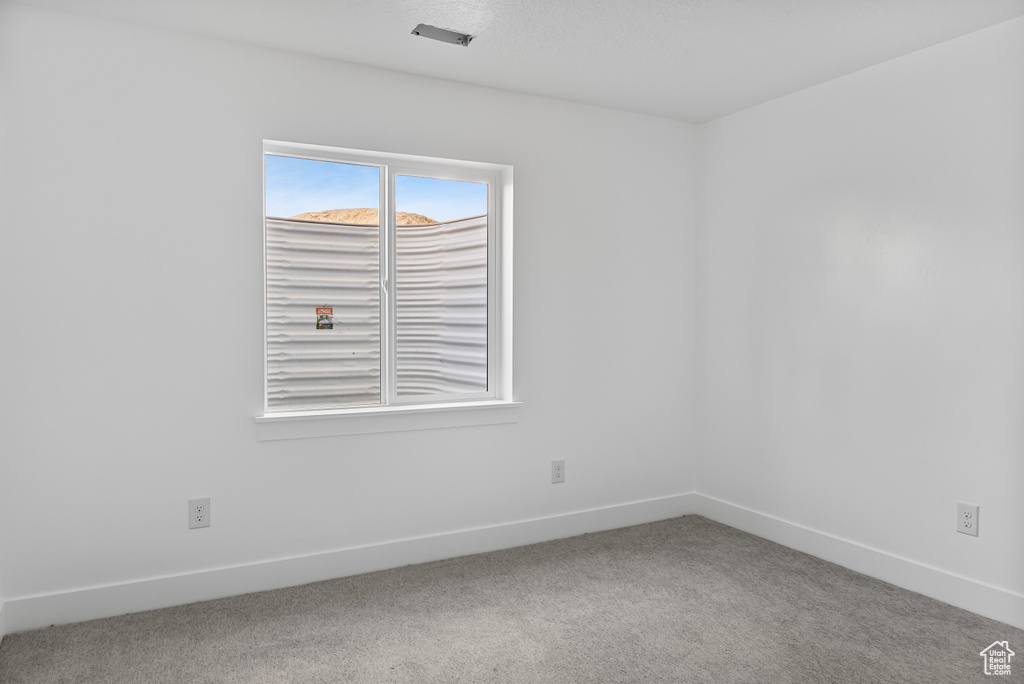 Carpeted empty room with baseboards
