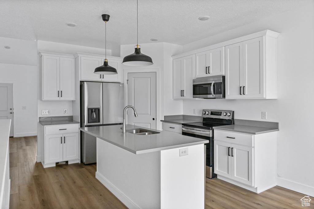 Kitchen featuring a sink, baseboards, appliances with stainless steel finishes, and light wood-style floors