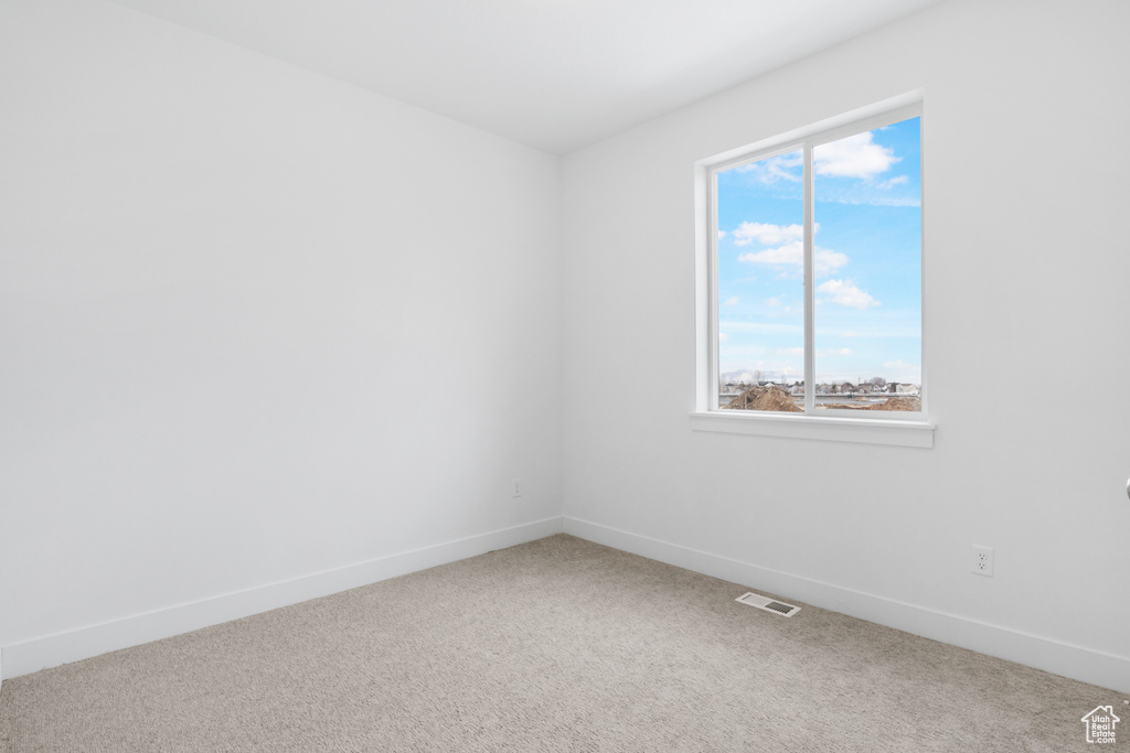 Spare room featuring visible vents, baseboards, and carpet floors