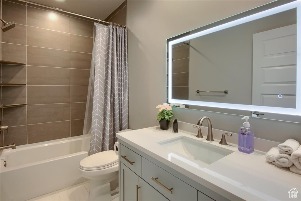 Bathroom with vanity, tile patterned flooring, toilet, and shower / tub combo with curtain