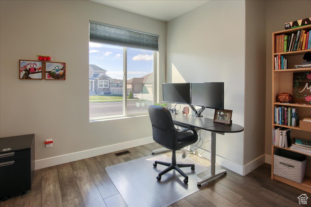 Home office with baseboards and wood finished floors