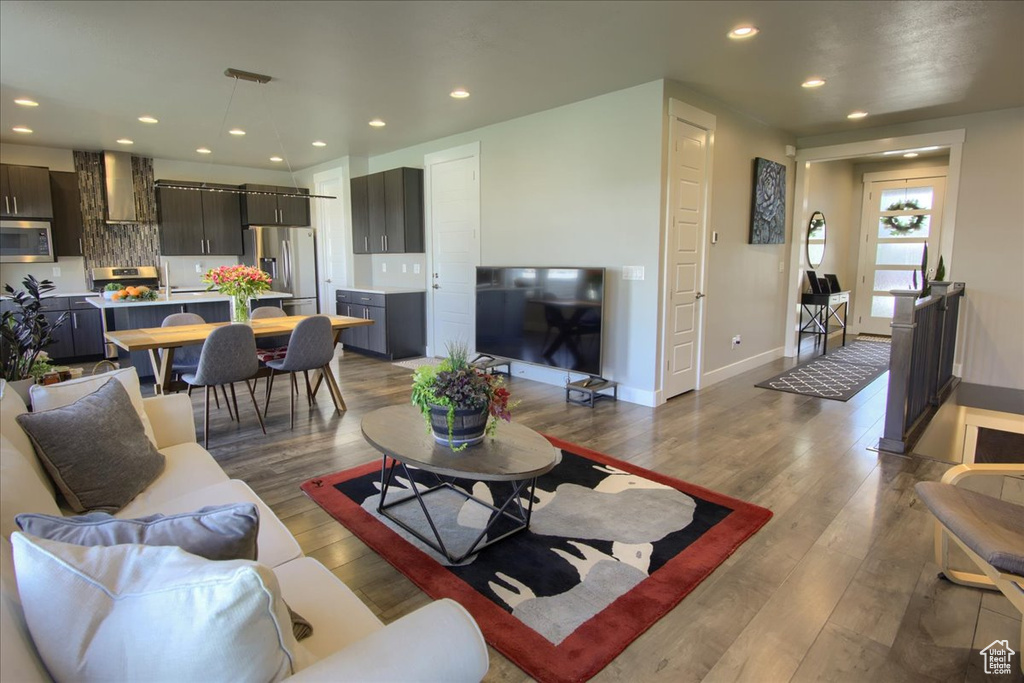 Living room with baseboards, recessed lighting, and hardwood / wood-style floors