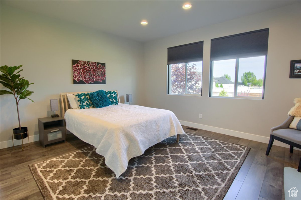Bedroom with baseboards, recessed lighting, wood finished floors, and visible vents