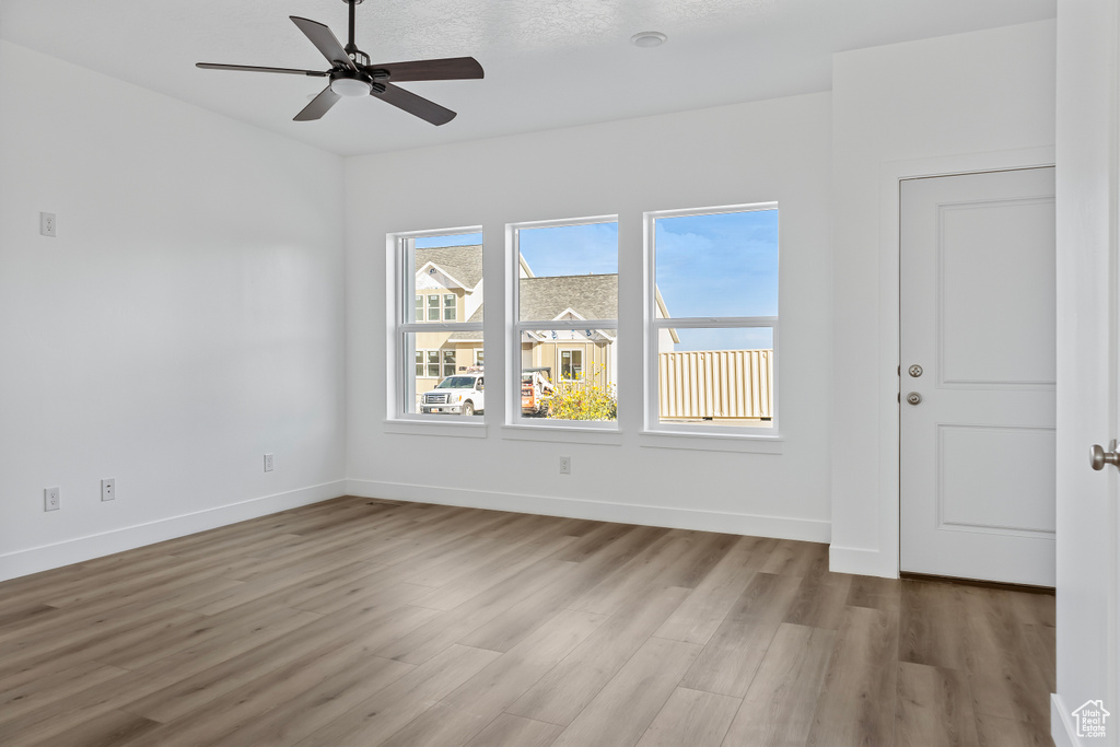Spare room with baseboards, wood finished floors, and ceiling fan