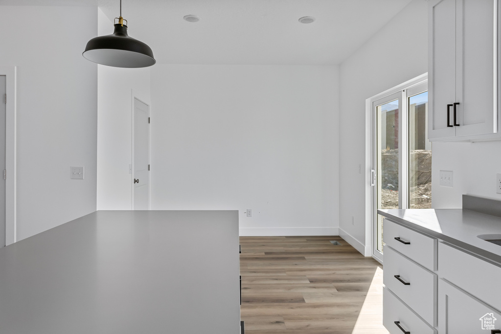 Unfurnished dining area featuring baseboards and light wood-type flooring