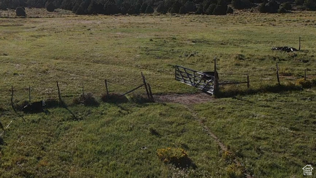 View of yard with fence and a rural view
