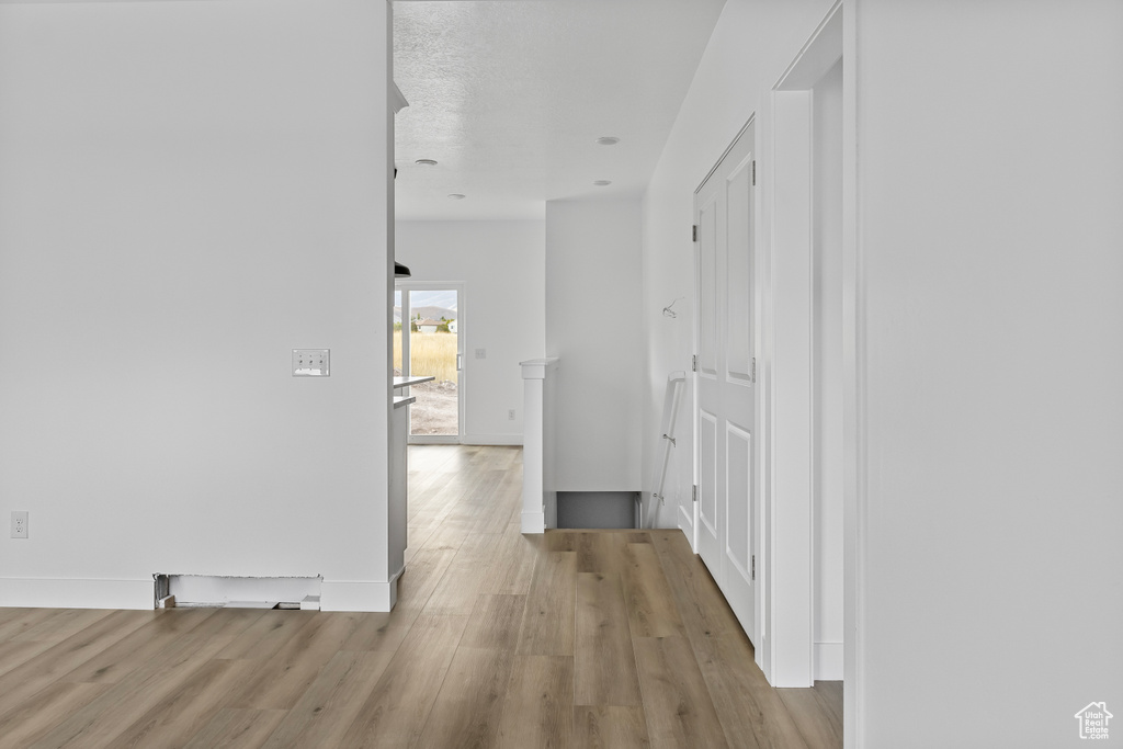 Hallway with wood finished floors and baseboards