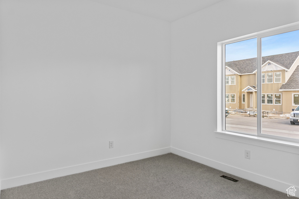 Spare room featuring baseboards, visible vents, and carpet