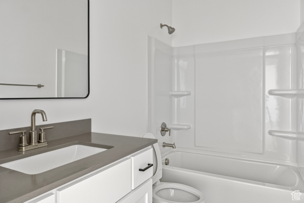 Bathroom with washtub / shower combination, toilet, and vanity