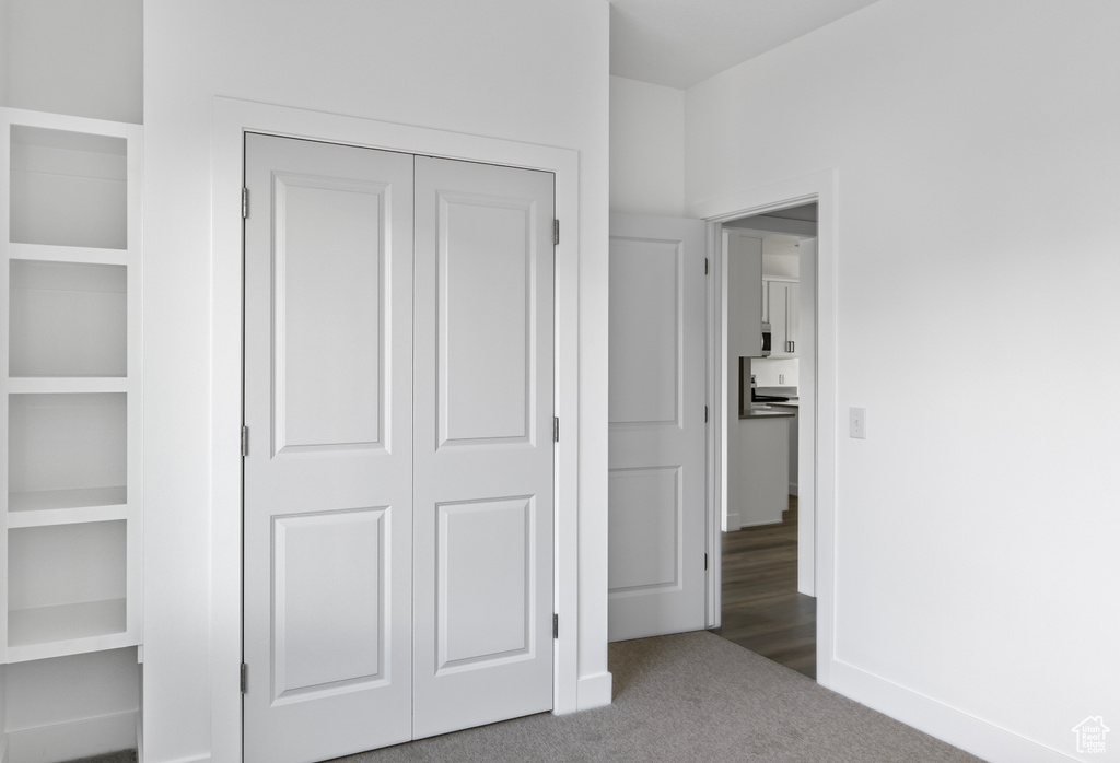 Unfurnished bedroom featuring carpet and a closet