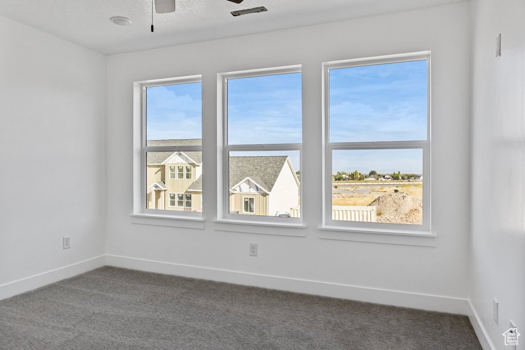 Spare room with baseboards, ceiling fan, and carpet flooring