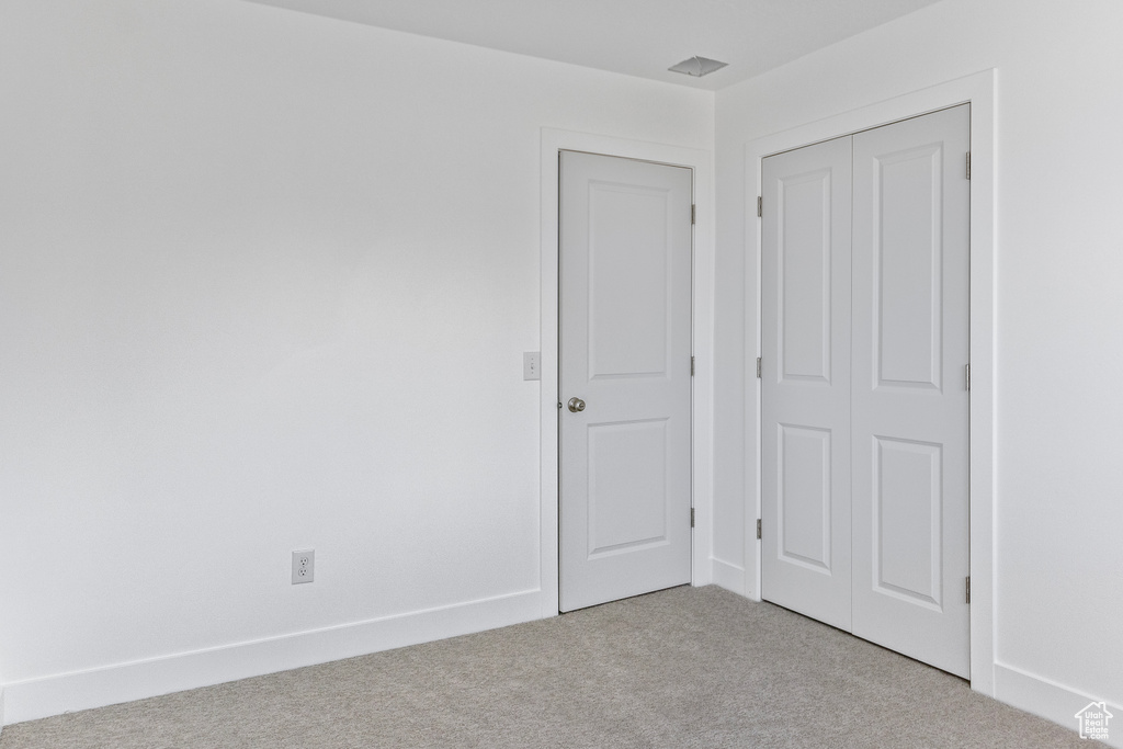 Unfurnished bedroom featuring a closet and carpet floors
