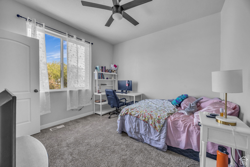 Carpeted bedroom with a ceiling fan, baseboards, and visible vents
