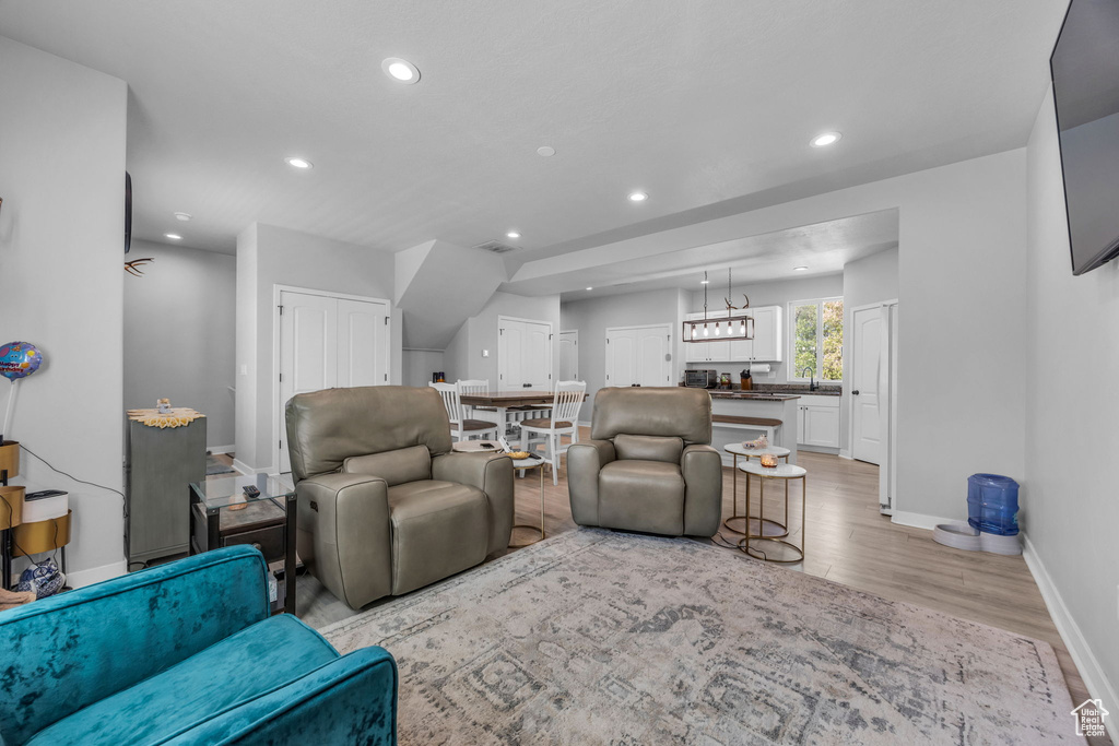 Living area with light wood-type flooring, recessed lighting, and baseboards