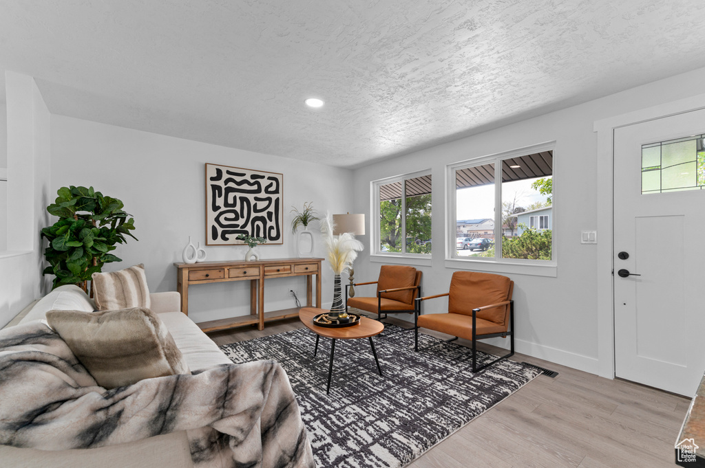 Living room featuring recessed lighting, baseboards, a wealth of natural light, and light wood-style flooring