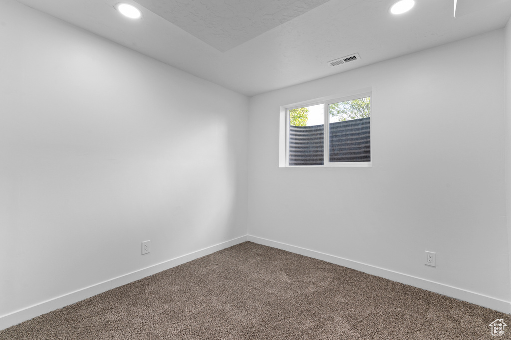 Spare room with recessed lighting, baseboards, visible vents, and dark colored carpet
