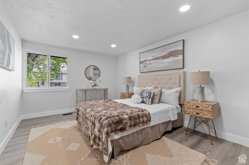 Bedroom featuring baseboards, recessed lighting, wood finished floors, and visible vents