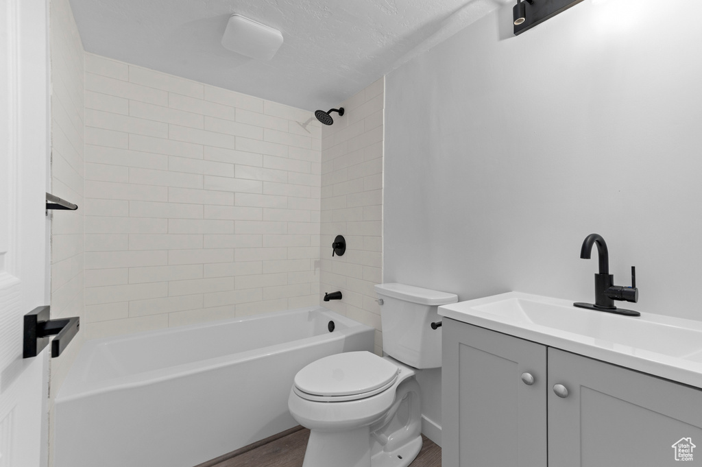 Full bath with vanity, wood finished floors, toilet, and shower / washtub combination
